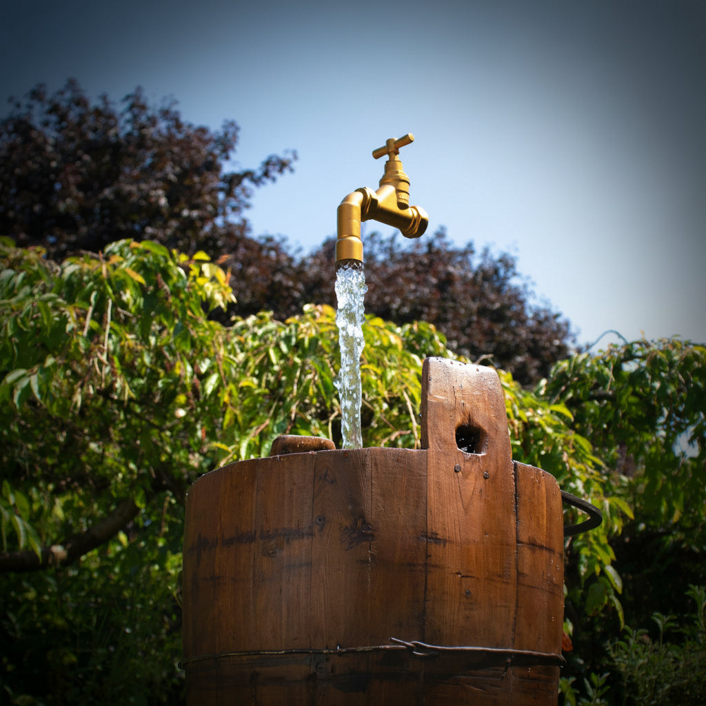 a floating tap sits on a column of water magically suspended above an antique water pail