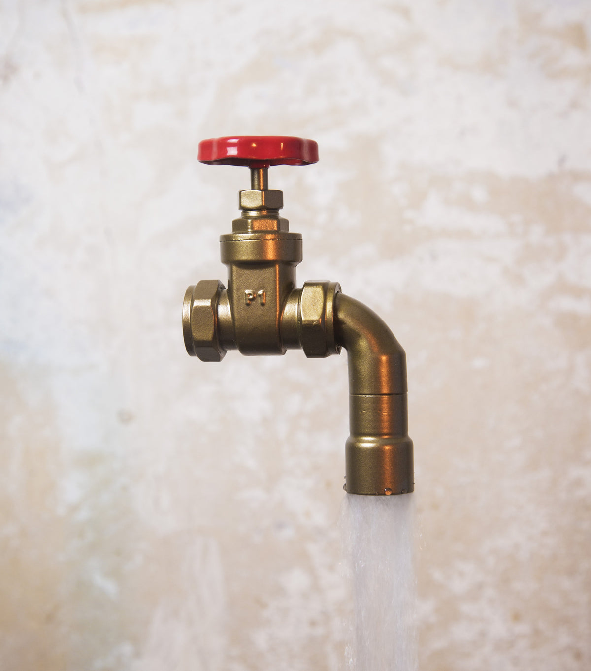 A floating tap water feature with a red gate valve tap with water flowing into the magically set in a industrial business environment.